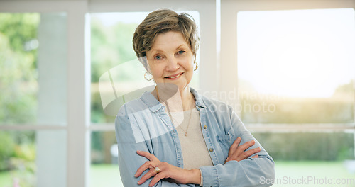 Image of Senior woman, portrait and arms crossed in retirement, morning and home with happiness and health. Elderly, person and smile on face in house to relax with sunshine in apartment, lounge or vacation