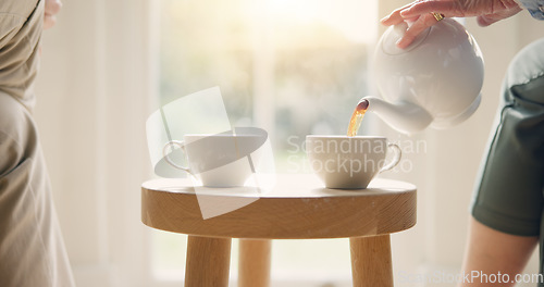 Image of Pot, pour and hands with tea cup in morning, home and closeup on drink, steam and table. Hot, beverage and person with hospitality, service and drinking in the afternoon with friends in living room