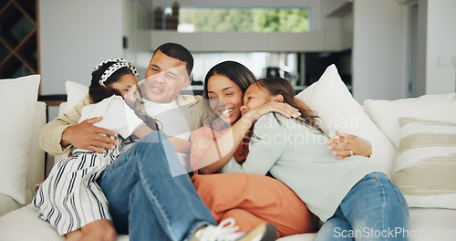 Image of Love, hug and happy family on a sofa with support, care and security in their home together. Smile, embrace and girl children with parents in a living room for bond, playing and having fun in a house