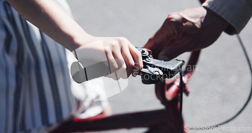 Image of Closeup, child and teaching bicycle ride for safety, parent and neighbourhood with hands. Cycling, childhood memory and riding in summer, bonding together and handlebar with bike bell for alert