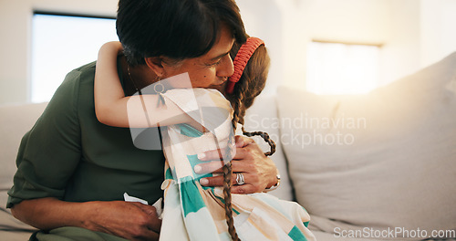 Image of Family, love and girl hugging her grandmother on a sofa in the living room of their home during a visit together. Trust, care and security with a senior woman embracing her grandchild in an apartment