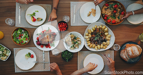 Image of Family home, top view and food on table with hands, plate and dish for festive celebration. Vegetables, bread and chicken in dining room, house and people together for social holiday brunch at event