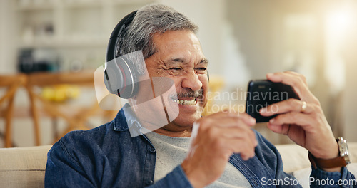 Image of Senior, man and headphone with phone in home for streaming, online and mobile app. Elderly person, smile and excitement for technology with connection, cellular or network for entertainment on web