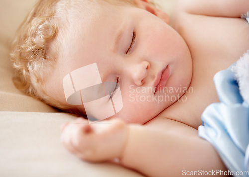 Image of Sleeping, baby and infant closeup in bed with peace and rest in morning nap for growth or development. Child, sleep and face in bedroom, home or dreaming in crib with a blanket and sheet with comfort