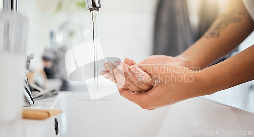 Image of Water, soap and clean woman hands in bathroom for covid 19, corona virus or healthcare safety. Cleaning and wellness background with a person washing bacteria in foam liquid for skincare or hygiene