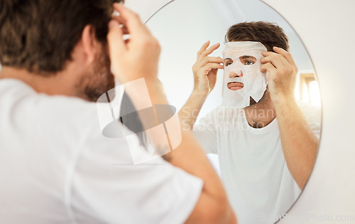 Image of Skincare, face and facial mask on man on mirror in home bathroom. Young male with self care, beauty or cosmetic cleaning for skin health and wellness for anti aging moisturizer product for detox