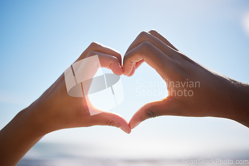 Image of Heart sign, beach hands and blue sky on vacation by the sea, happy on international holiday in Miami and love for summer travel in nature. Person with emoji for happiness by the ocean in spring