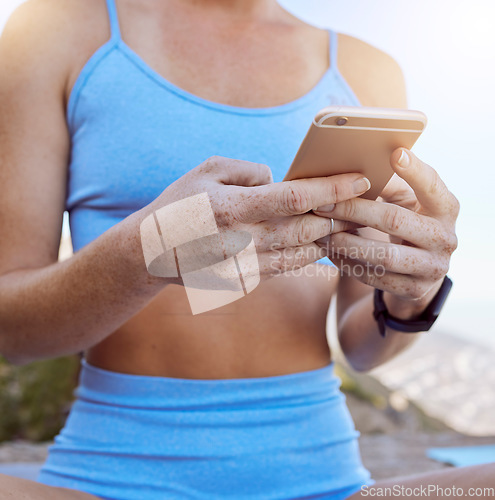 Image of Woman hands, fitness app and phone typing outdoor in workout videos, exercise tutorial and workout music playlist. Closeup yoga girl reading social media, mobile notification and online virtual coach