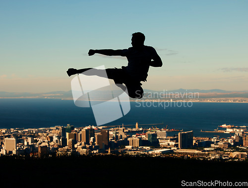 Image of Silhouette of man doing karate with sky and city in the background. Outline of male athlete punching and kicking in the air in martial arts motion. Motivation, inspiration and urban warrior