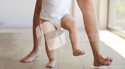 Image of Baby, learning and walking with a child taking its first steps with his mother to learn to walk at home. Feet, legs and balance with a kid stepping forward for growth and development in the house