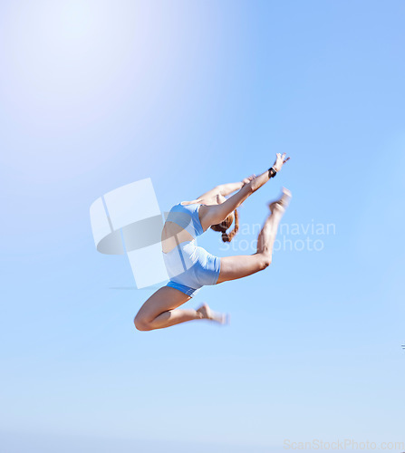 Image of Fitness, jumping and sky with a sports woman mid air outdoor against a clear blue background during summer. Workout, exercise and training with a female athlete leaping for health and wellness