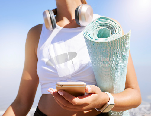 Image of Fitness, yoga and woman on a phone in nature, texting and listening to music before summer outdoor workout. Radio, podcast and wellness exercise with female relax while searching for online playlist