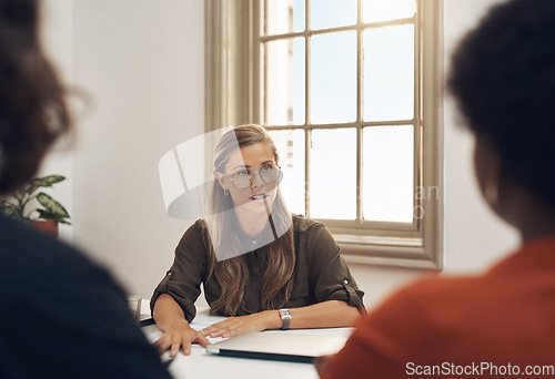 Image of Human resources manager meeting with colleagues, settling a dispute or argument in her office. Serious female leader talking, meeting and planning with her team and staff members at work