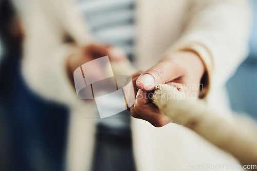 Image of Teamwork, hands and tug and war while joining forces and pulling a rope for battle against competitors. Closeup of strong businessperson fighting for power, leadership and equality rights