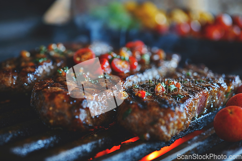 Image of Large juicy beef rib eye steak on a hot grill