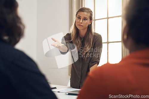 Image of Young, upset and professional businesswoman in a meeting with two workers having an argument. Group, team or people training and discussing at the office or leader blaming worker for poor performance