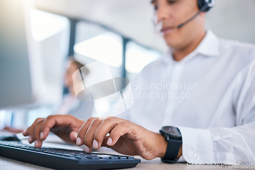 Image of Call center agent hands or CRM consultant typing client information on PC keyboard while talking on phone with headset. Contact us for customer service or telemarketing hotline support assistance.