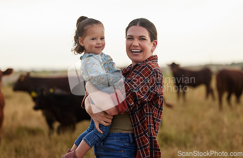 Image of Family, mother and baby on a farm with cows in the background eating grass, sustainability and agriculture. Happy organic dairy farmer mom with her girl and cattle herd outside in sustainable nature