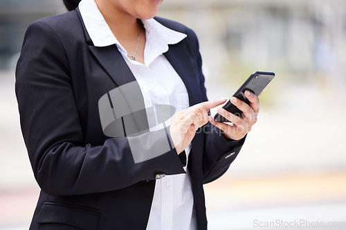 Image of Online, networking business woman in a suit and smartphone reading email communication, WhatsApp or mobile project management app on the go. Corporate professional hands typing on smartphone in city