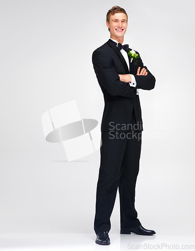 Image of Wedding, marriage and groom with a handsome man standing arms crossed in studio against a white background. Happy male in a suit or tuxedo with a smile ready to get married at a celebration event