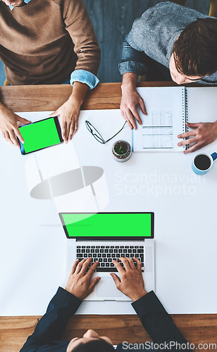 Image of Green screen, copyspace and chromakey on the screen of a laptop and tablet in an office from above. Business people in a meeting, discussing marketing and advertising strategy in the boardroom