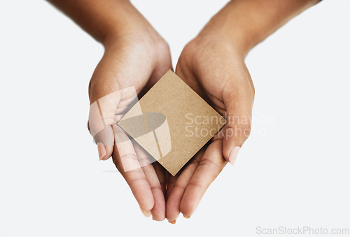 Image of Closeup of the hands of a person showing a message, advertising a product or holding an empty paper or a cardboard card against a white background. Top view of woman promoting an item or sign