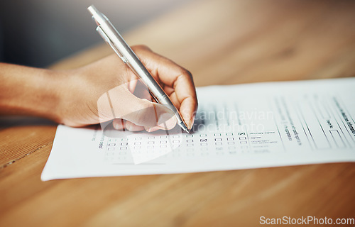 Image of Her opinion matters. Closeup of a female hand filing in paperwork for a formal application or survey. A woman writing on a form applying for a financial loan, completing a list or questionnaire.