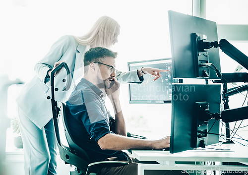 Image of Stock broker business team trading online watching charts and data analyses on multiple computer screens in modern corporate work station office.