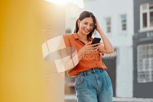 Image of Woman texting, browsing and scrolling on phone while chatting on social media, waiting for taxi and commuting in an urban city. Happy, trendy and smiling female tourist reading online notification