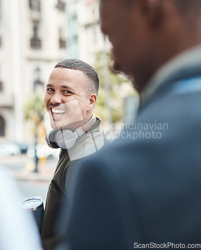 Image of Real life young man portrait in the street with headphones, enjoying music on a playlist app looking happy, stressless and cool. Normal face of a millennial with wireless tech outside an urban city