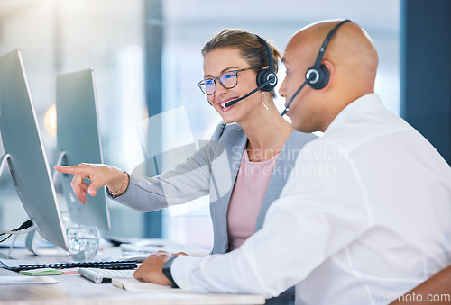 Image of Call centre agent, telemarketing and sales representative colleague with desktop computer talking, showing or looking at online software app or website. Global business agency manager discussing work