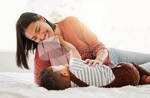 Image of Happy, love and family time with a mother and son being playful and bonding on a bed at home. Parent playing with her child, smiling and enjoying motherhood. Single mom embracing her son.