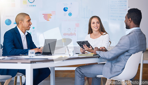 Image of Networking, negotiating and professional business partners having a meeting in an office, talking and smiling. Diverse entrepreneurs collaborating on digital design project, planning and discussing