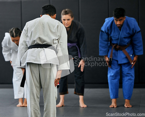 Image of Fitness, strength and respect between karate trainer leading a class, bow and greeting martial arts student at a dojo or studio. Diverse group training and learning self defense and endurance skills