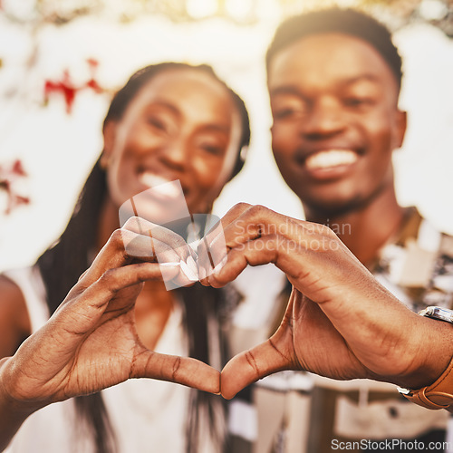 Image of Heart hands, emoji and love of couple smile, happy and showing kindness, trust and support. Closeup of young black people together in romantic relationship celebrate honeymoon with with content bond