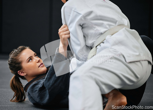 Image of Strong, female and martial arts fighter training at an exercise studio with an opponent. Fit, young and active woman in a defense lesson at a dojo. Athlete lady practicing jujutsu with a partner.