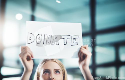 Image of Donate, volunteer and give back to the community with a sign in the hands of a young woman inside. Closeup of a poster with text looking for welfare aid, donations and contributions to society