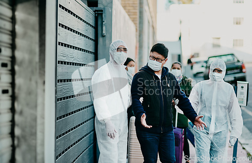 Image of Man breaking covid regulation getting taken away or arrested by healthcare workers wearing hazmat protective suits. Male removed for not following the rules or restrictions of coronavirus pandemic