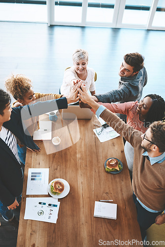 Image of Diverse group of businesspeople high five after planning a meeting in an office. Above ambitious happy confident professional team of colleagues celebrating a success, achievement and feeling excited