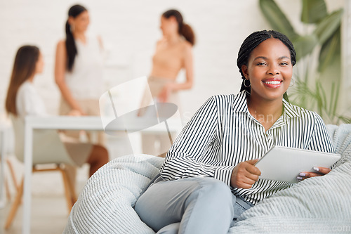 Image of Creative black woman on social media, with tablet and checking online while on a work break. Happy young lady boss of ecommerce startup, relaxing before a business meeting business with her girl team