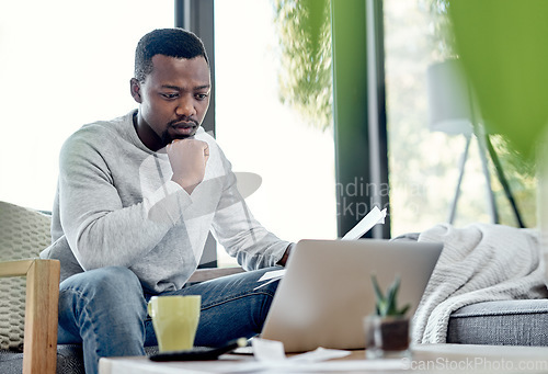 Image of Finance, stress and worried black man paying bills on a laptop while doing paperwork at home. Concerned, anxious male checking budget, getting bad news or negative feedback of a rejected loan or debt