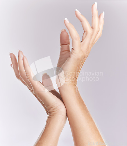 Image of Soft, manicure hands or beauty treatment closeup of female model palms touching in elegant hand pose isolated on purple studio background. Skincare, nails care or antiaging wrinkle free body part