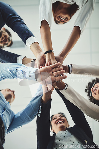 Image of Hands stacked and piled showing team unity, strength or motivation among creative business colleagues from below. Excited, laughing and huddled group of inspired business people ready for success