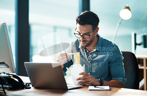 Image of Business man eating lunch at his desk, reading an email on a laptop and working overtime in office. Corporate professional, manager or employee completing a deadline and browsing internet for ideas