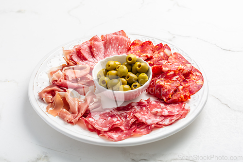 Image of Assortment of Italian and Spanish sliced meat appetizer, prosciutto, salami and ham, with olives