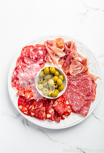 Image of Assortment of Italian and Spanish sliced meat appetizer, prosciutto, salami and ham, with olives