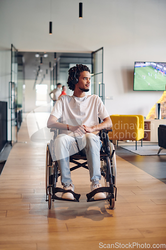 Image of A businessman in a wheelchair occupies a hallway within a modern startup coworking center, embodying inclusivity and determination in the business environment