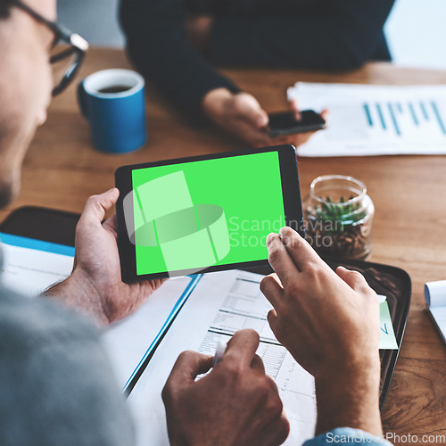 Image of Green screen, copyspace and chromakey on a tablet screen in the hands of a business man sitting in the boardroom during a meeting. Talking and planning for marketing, advertising and online promotion