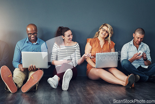 Image of Diverse modern group of business people sitting on social media networking apps on their digital devices. creative team of work colleagues connected online with laptop pcs and phones