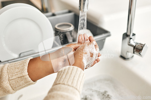 Image of Hygiene, cleaning and washing hands with soap and water in the kitchen sink at home. Closeup of a female lathering and rinsing to disinfect, protect and prevent the spread of virus and germs